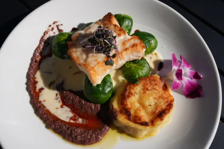 Close-up of the pan-seared fish special with microgreens and orchid garnish
